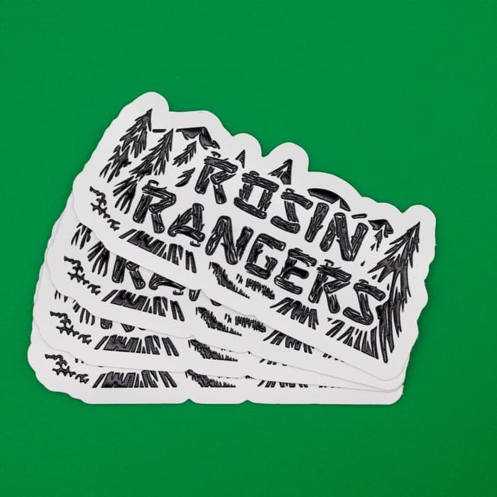 A stack of white die-cut stickers on a green background